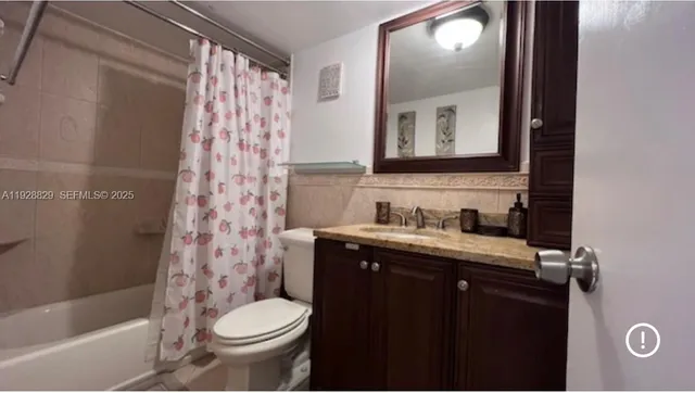 a bathroom with a granite countertop toilet sink and mirror