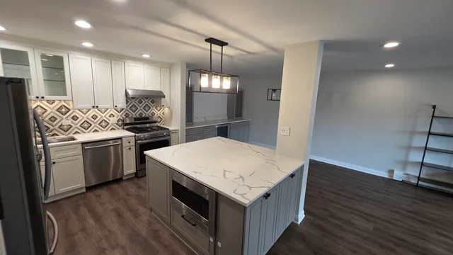 a kitchen that has a lot of cabinets a sink and a stove