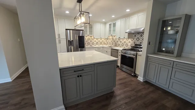 a kitchen with kitchen island white cabinets and stainless steel appliances
