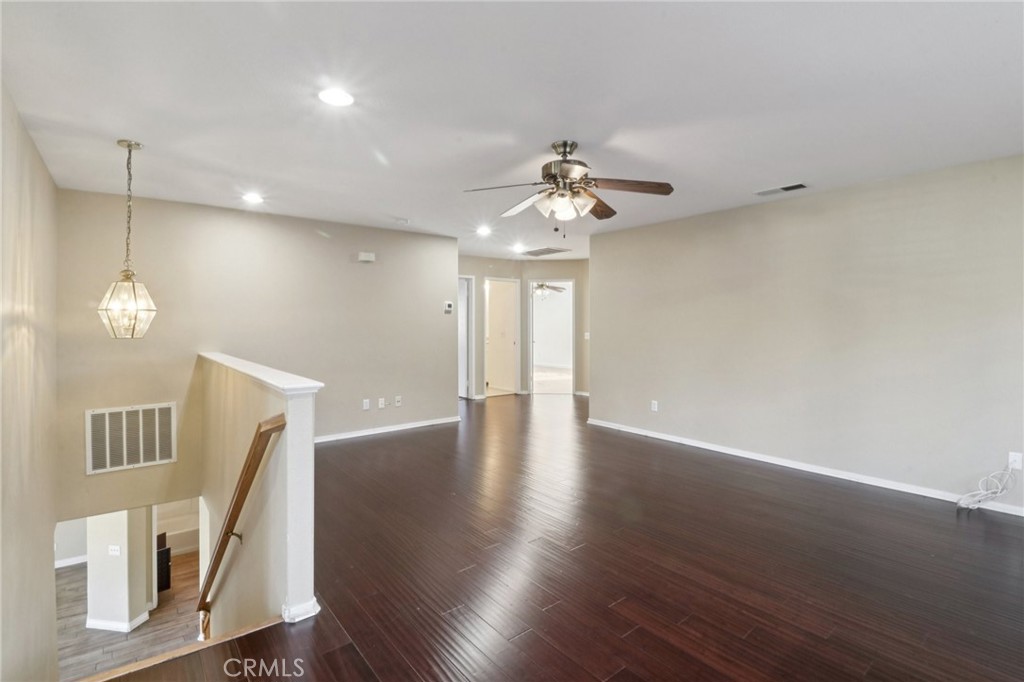 4310 Forest Ranch Way Oceanside, CA 92057 - Photo 25 of 50 a view of a livingroom with wooden floor and a ceiling fan