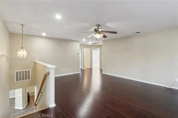 a view of a livingroom with wooden floor and a ceiling fan