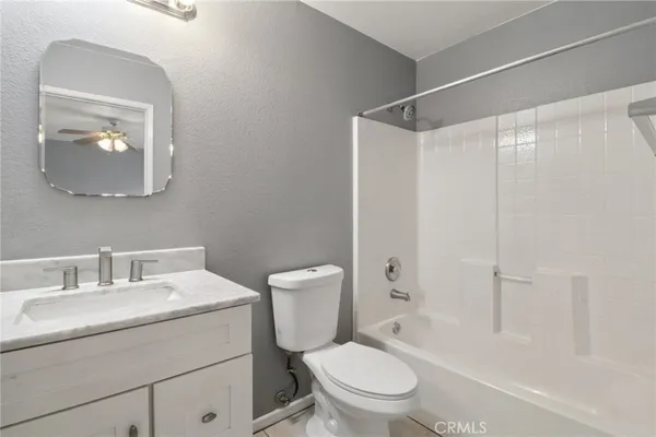 a bathroom with a toilet sink vanity and shower