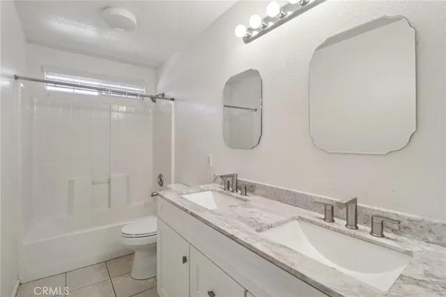a bathroom with a granite countertop sink a toilet and a mirror