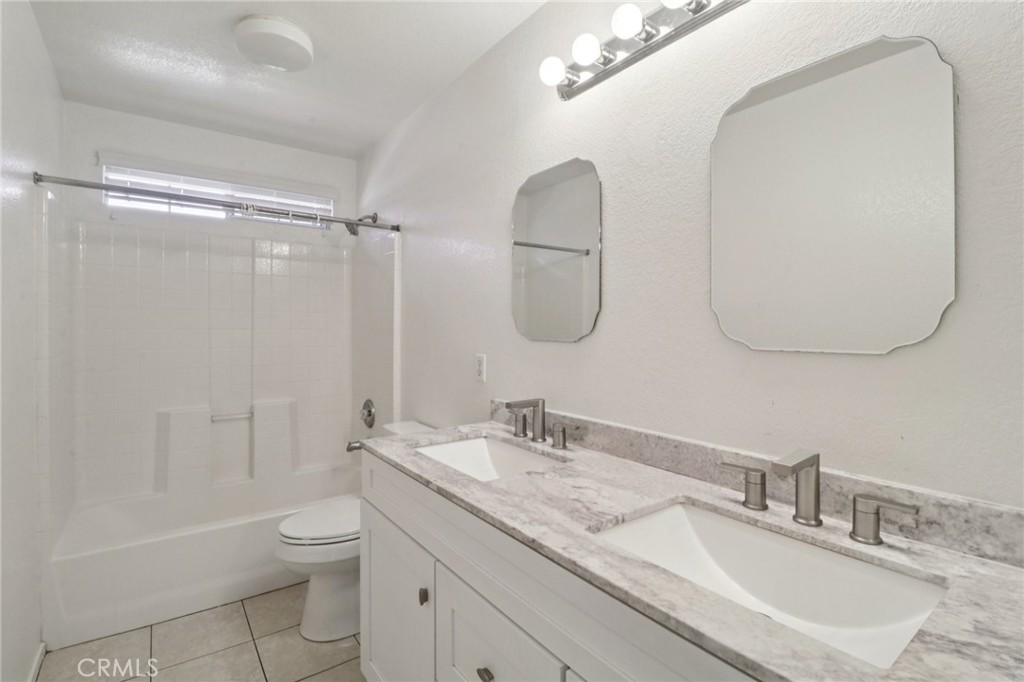4310 Forest Ranch Way Oceanside, CA 92057 - Photo 31 of 50 a bathroom with a granite countertop sink a toilet and a mirror