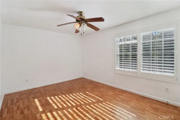 a view of a big room with wooden floor and windows
