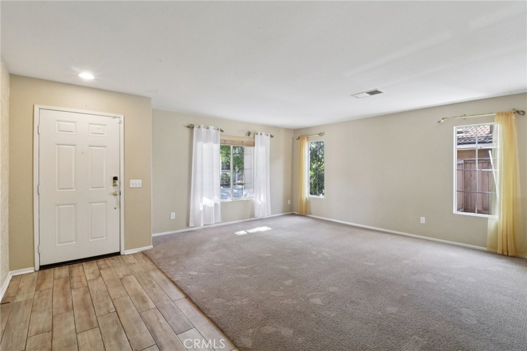 4310 Forest Ranch Way Oceanside, CA 92057 - Photo 5 of 50 a view of an empty room with wooden floor and a window