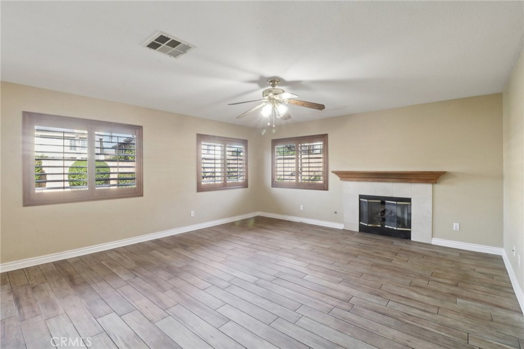 4310 Forest Ranch Way Oceanside, CA 92057 - Photo 10 of 50 an empty room with windows a fireplace and wooden floor