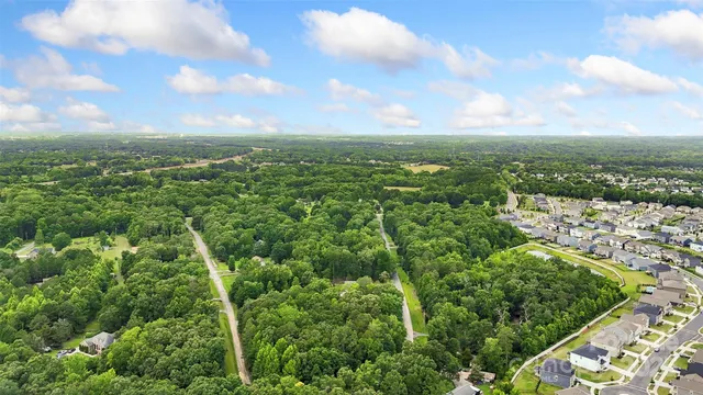 an aerial view of residential house with outdoor space and trees all around