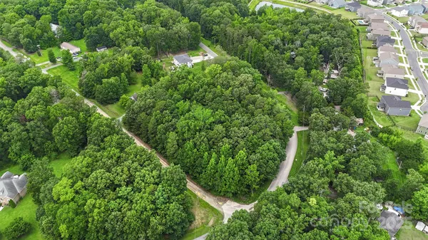 an aerial view of residential house with space and trees all around