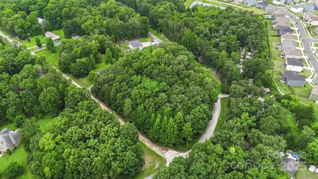 an aerial view of residential house with space and trees all around