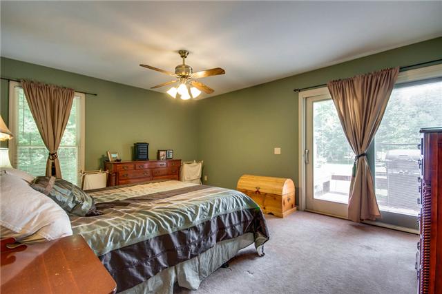 7378 Walker Road Fairview, TN 37062 - Photo 9 of 20 Master bedroom with ceiling fan and doors that take you to the outside deck and then to open yard with woods on both sides. What a view!