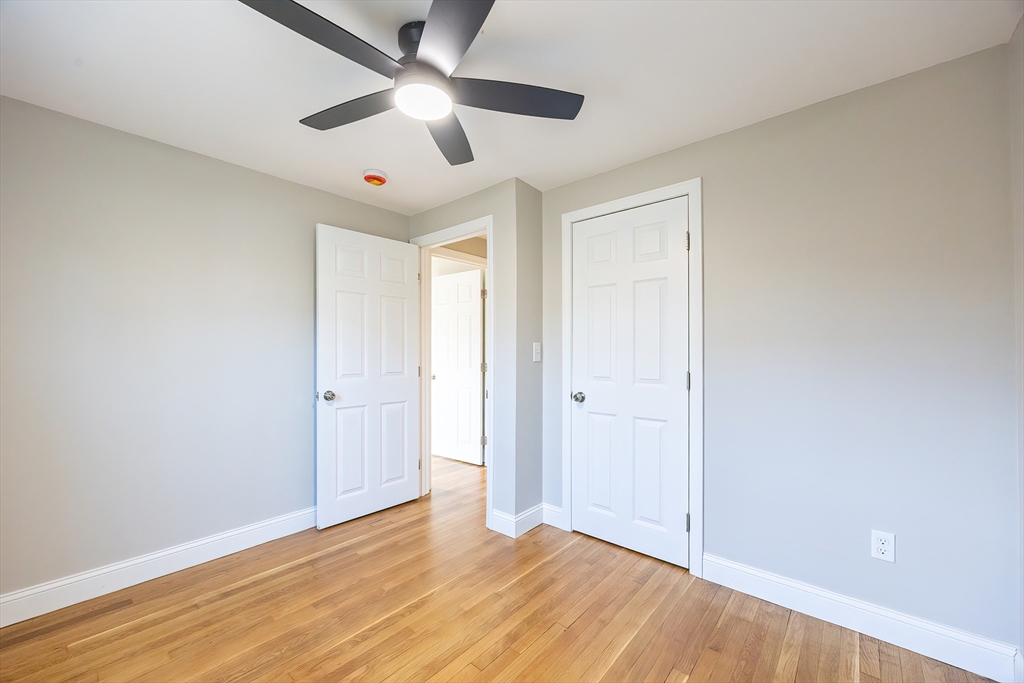 1123 County Street Attleboro, MA 02703 - Photo 15 of 20 an empty room with wooden floor ceiling fan and windows