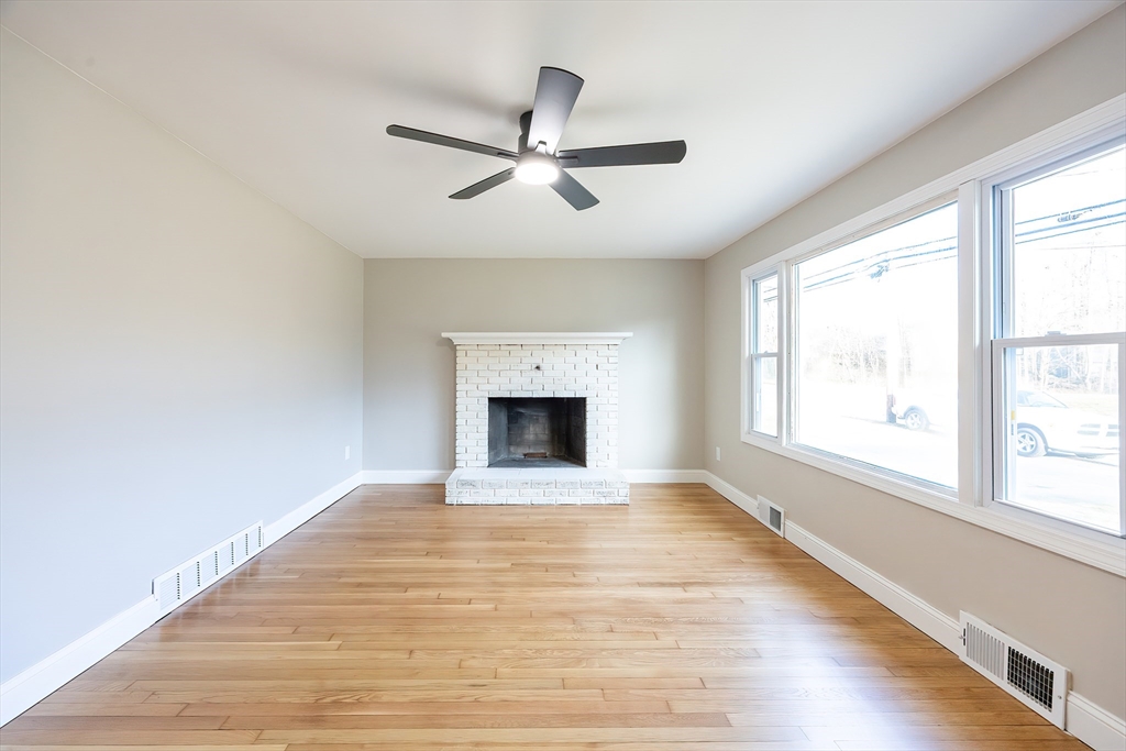 1123 County Street Attleboro, MA 02703 - Photo 6 of 20 an empty room with wooden floor fan and windows