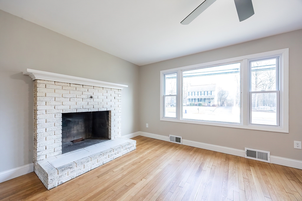 1123 County Street Attleboro, MA 02703 - Photo 7 of 20 a view of an empty room with wooden floor fireplace and a window