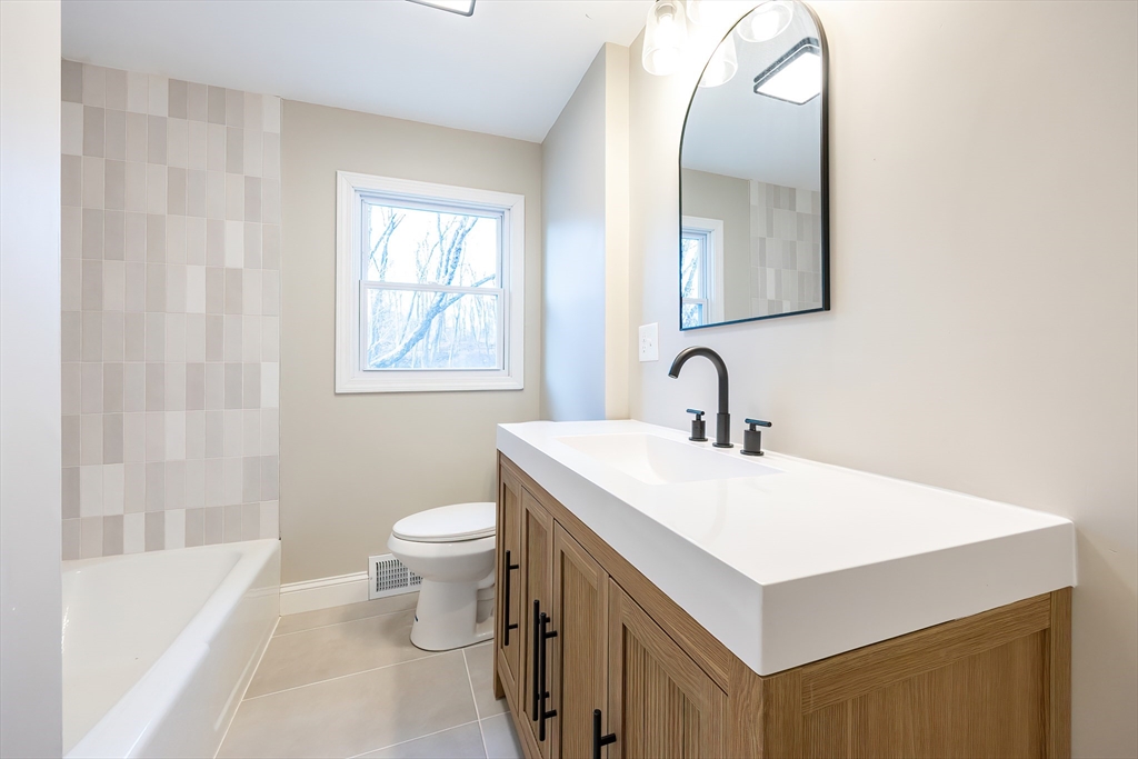 1123 County Street Attleboro, MA 02703 - Photo 8 of 20 a bathroom with a sink a toilet and a mirror