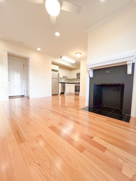 219 Commonwealth Avenue, Unit 21 Newton, MA 02467 - Photo 8 of 9 a view of empty room with wooden floor and fireplace