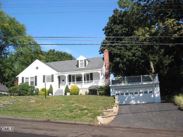 a view of a white house with a yard and plants