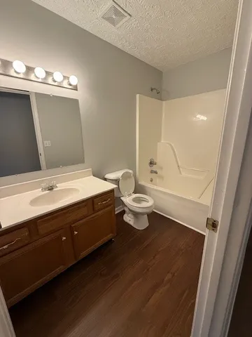 a bathroom with a double vanity sink toilet and mirror