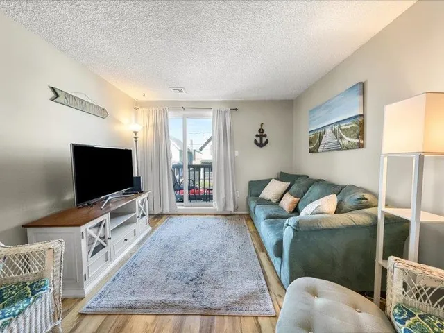 a living room with furniture wooden floor and a dining table