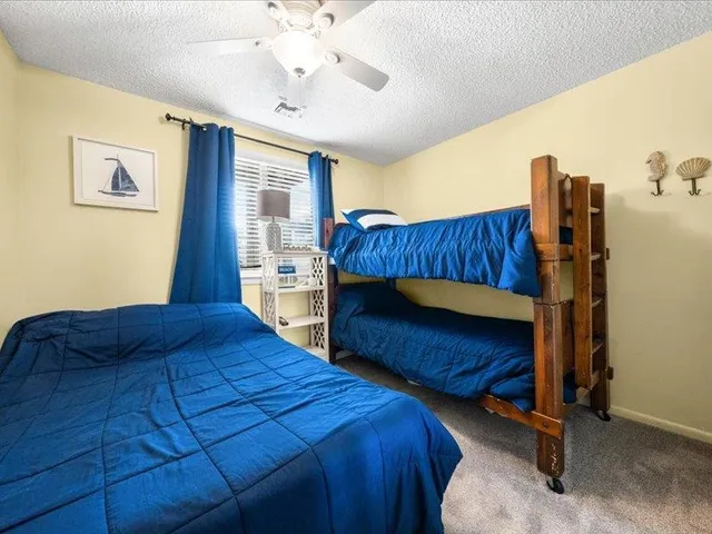 a bedroom with a bed and large windows