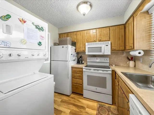 a kitchen with a sink cabinets appliances and a window