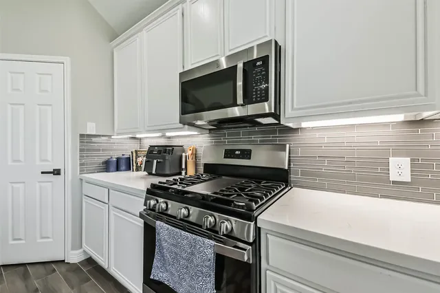 a kitchen with stainless steel appliances granite countertop a stove and a microwave