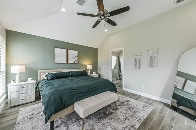a bedroom with a bed a rug and wooden floor