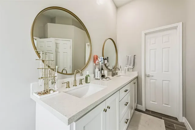 a bathroom with a double vanity sink and a mirror