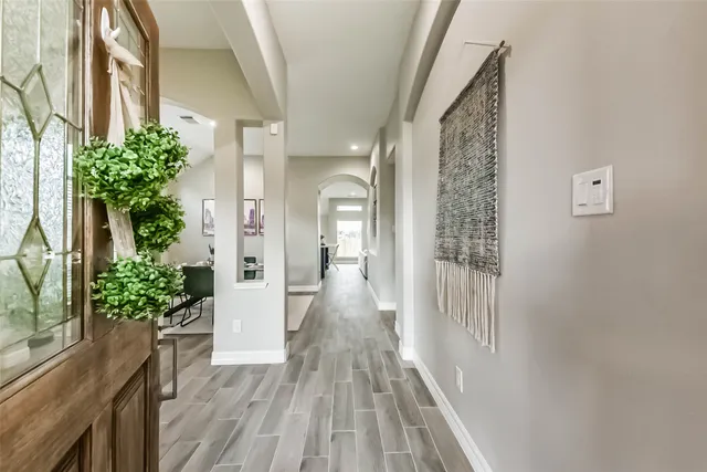 a view of a hallway with wooden floor and glass door