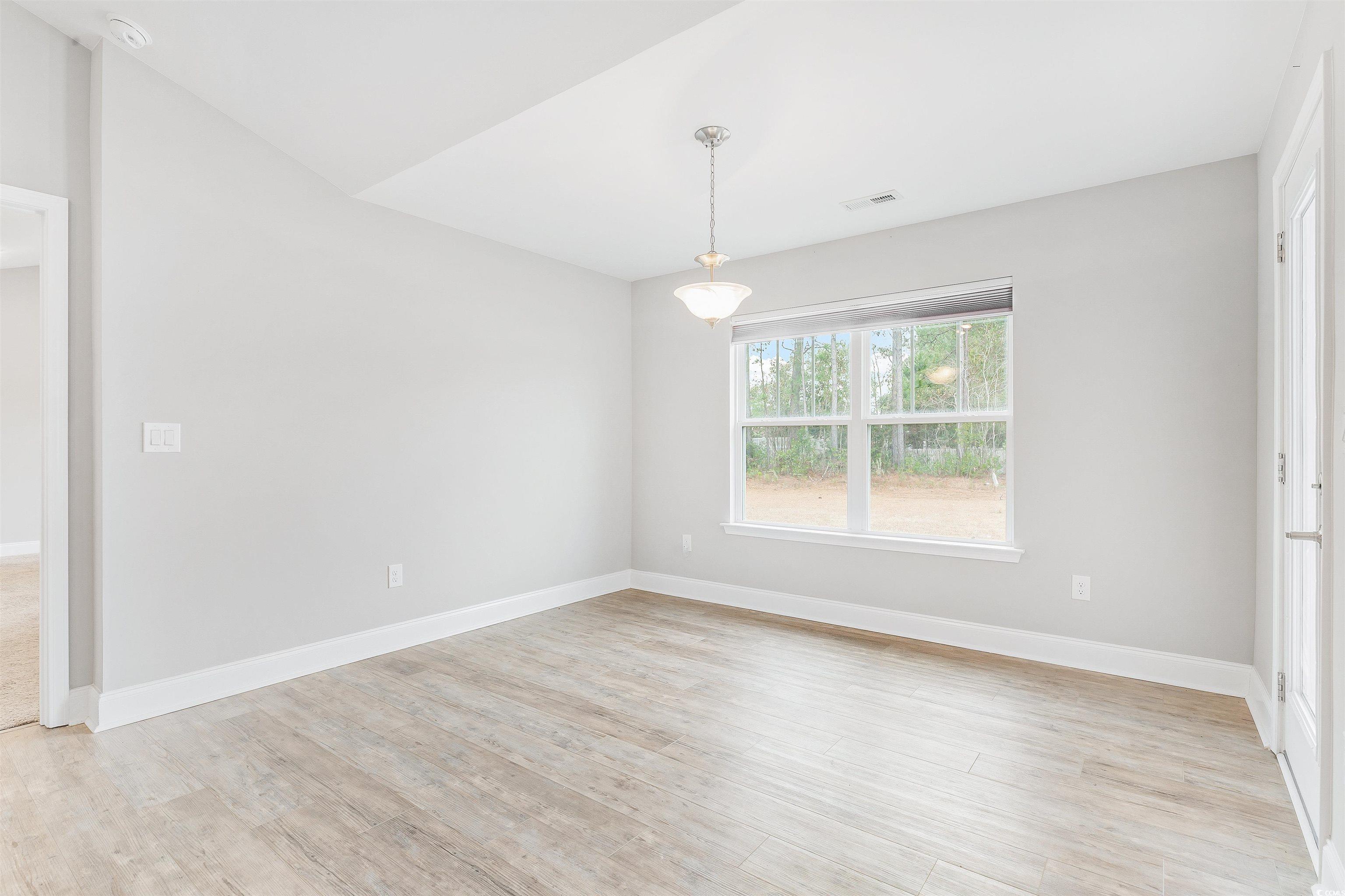 317 Marsh Tacky Loop Myrtle Beach, SC 29588 - Photo 12 of 29 Empty room with light hardwood / wood-style floori