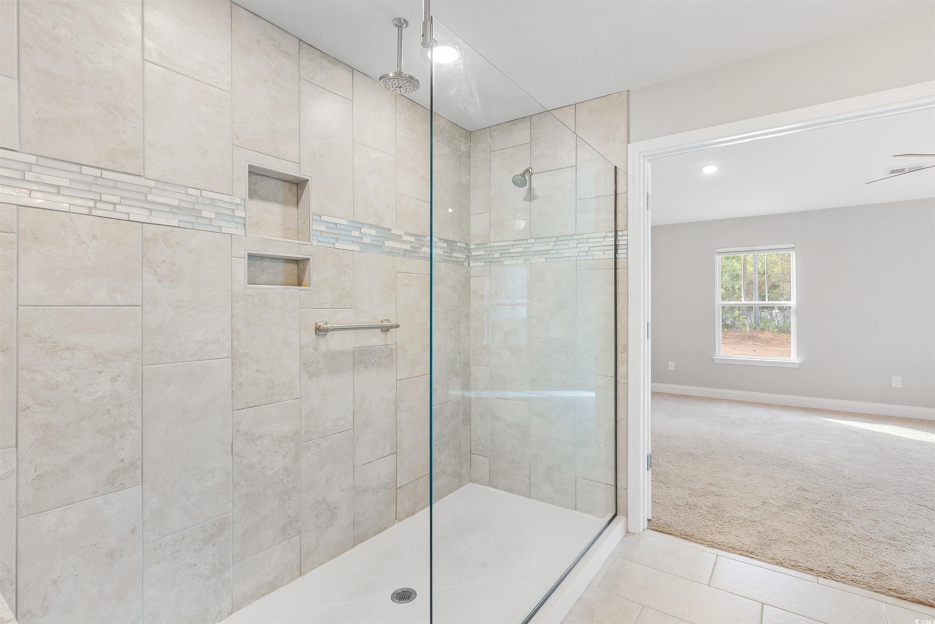 317 Marsh Tacky Loop Myrtle Beach, SC 29588 - Photo 16 of 29 Bathroom with a tile shower, ceiling fan, and tile