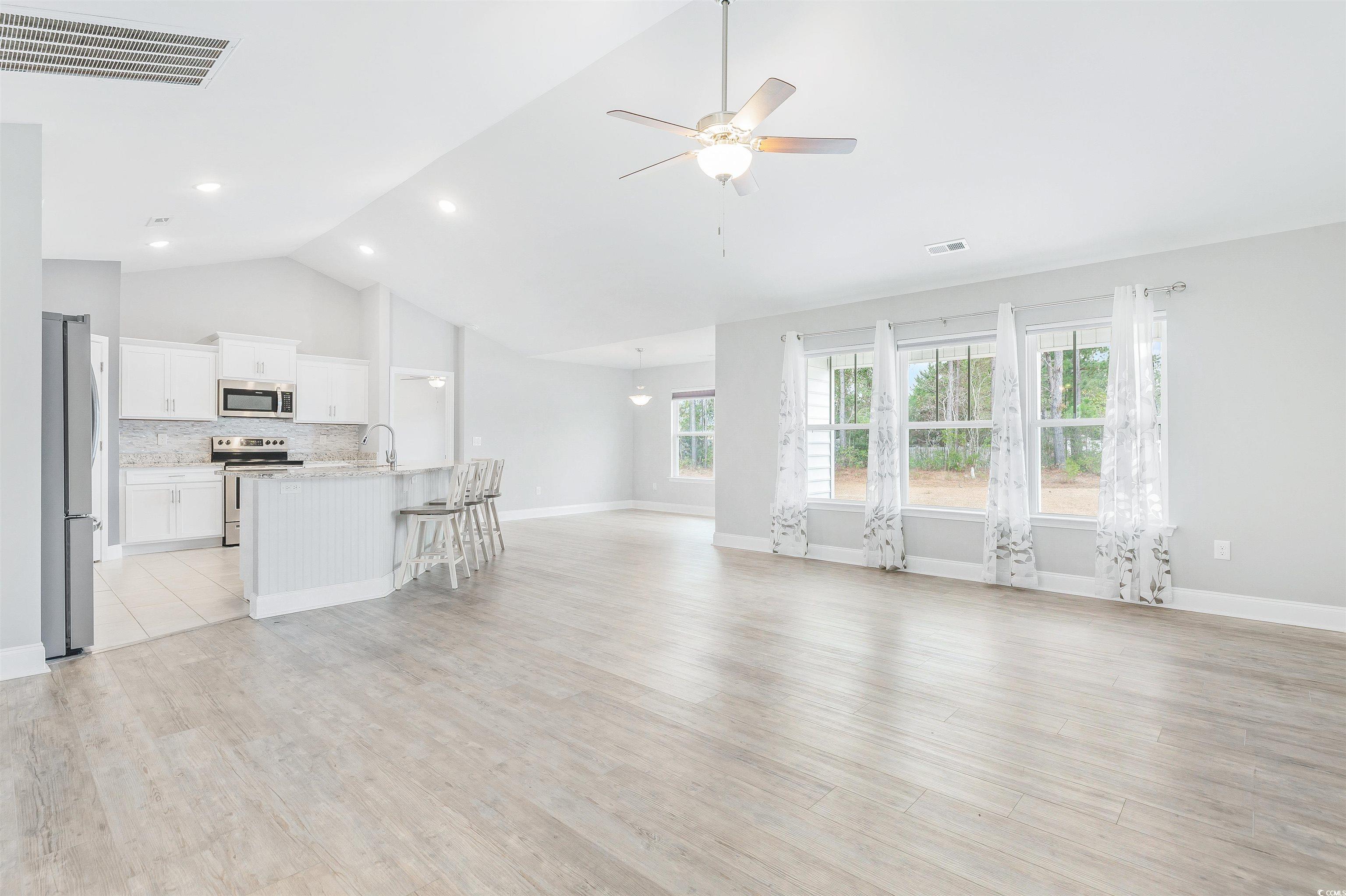 317 Marsh Tacky Loop Myrtle Beach, SC 29588 - Photo 7 of 29 Unfurnished living room with ceiling fan, light wo