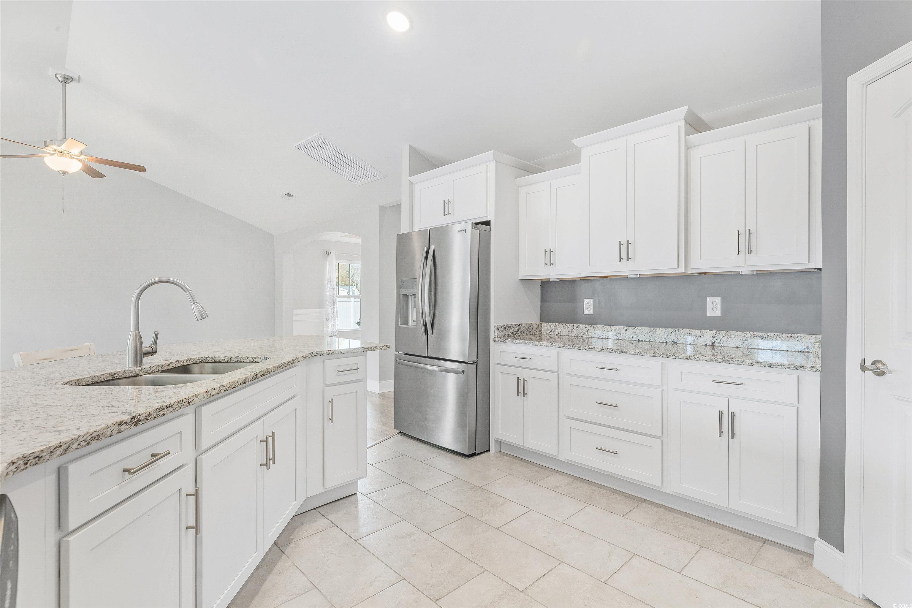 317 Marsh Tacky Loop Myrtle Beach, SC 29588 - Photo 9 of 29 Kitchen featuring sink, white cabinets, lofted cei
