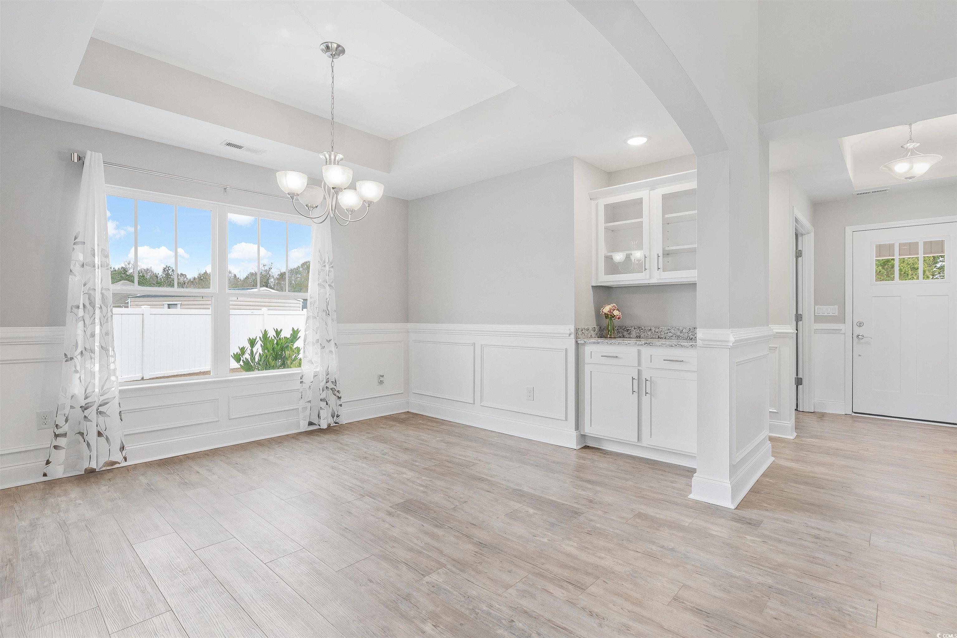 317 Marsh Tacky Loop Myrtle Beach, SC 29588 - Photo 10 of 29 Unfurnished dining area with a raised ceiling, a h