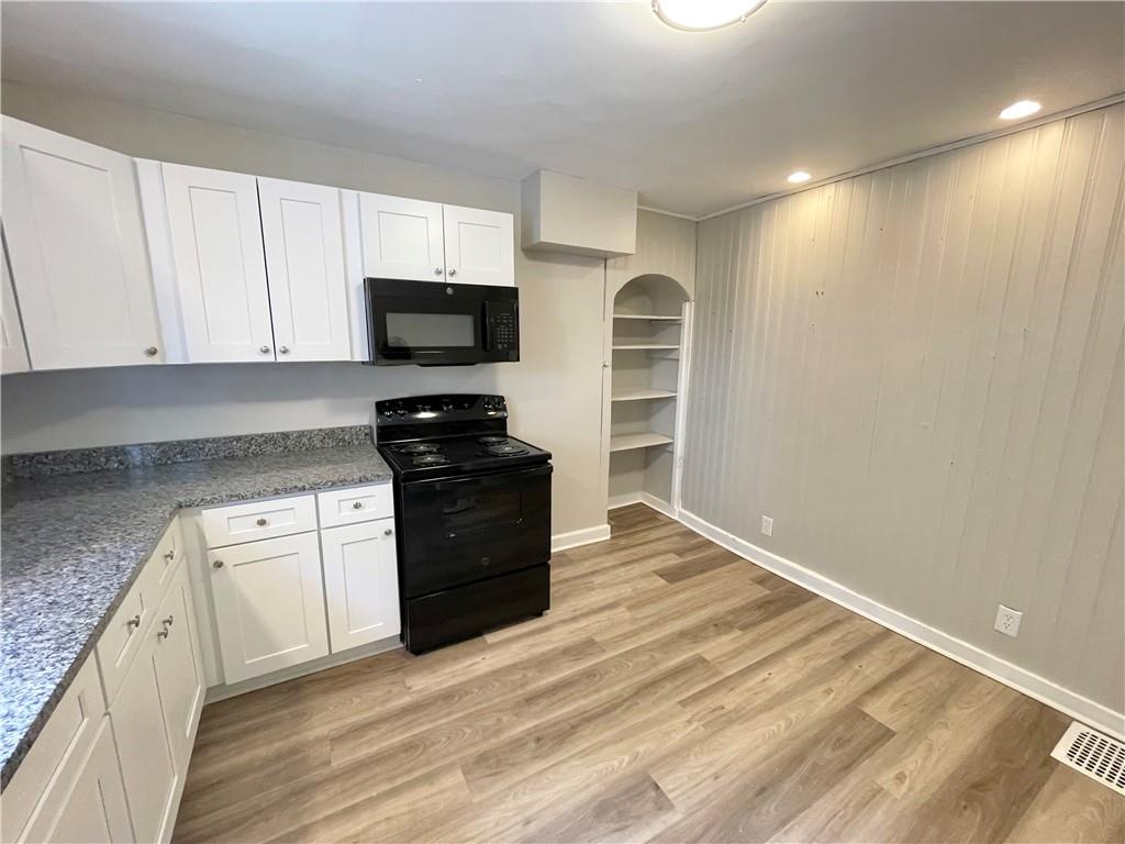 223 East Falls Street, Unit 1B New Castle, PA 16101 - Photo 6 of 14 a kitchen with granite countertop a refrigerator and a stove top oven