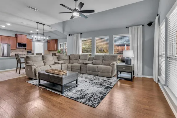 a living room with furniture ceiling fan and a window