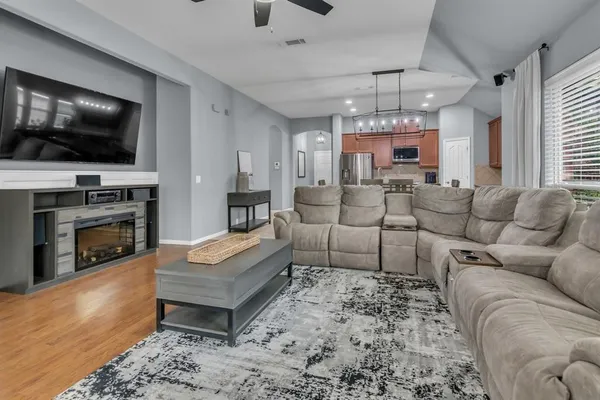 a living room with furniture a flat screen tv and a fireplace