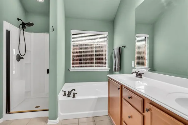 a bathroom with a tub sink and mirror