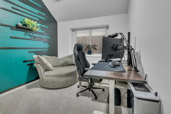 a view of a workspace with furniture and a window