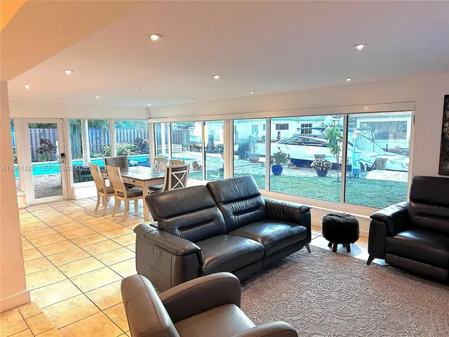 a living room with furniture a rug and a floor to ceiling window