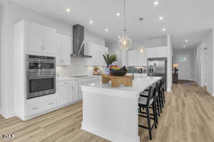 1111 Masters Place Way Durham, NC 27703 - Photo 2 of 37 a kitchen with stainless steel appliances kitchen island granite countertop a stove a sink and a microwave