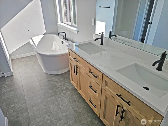 a spacious bathroom with double vanity and mirrors