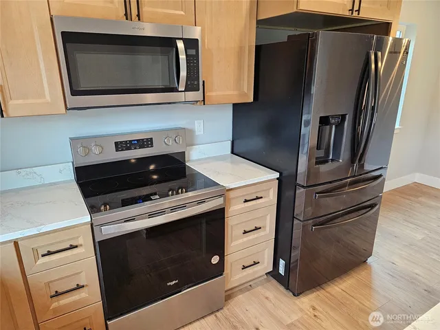 a kitchen with granite countertop cabinets and steel stainless steel appliances