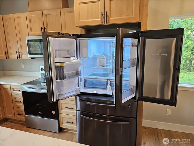 a kitchen with stainless steel appliances granite countertop a refrigerator and a stove