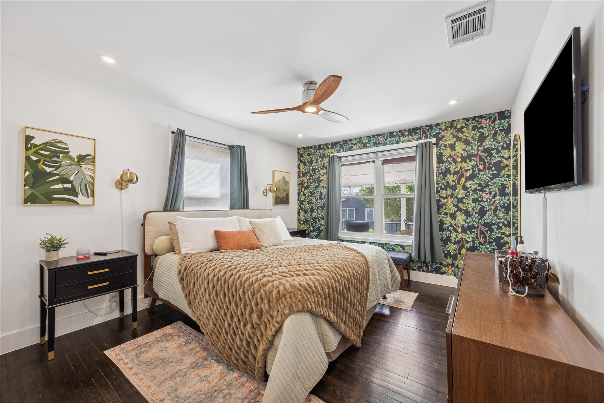 2306 Santa Maria Street Austin, TX 78702 - Photo 11 of 17 a bedroom with a bed a couch and a flat tv screen on the dresser