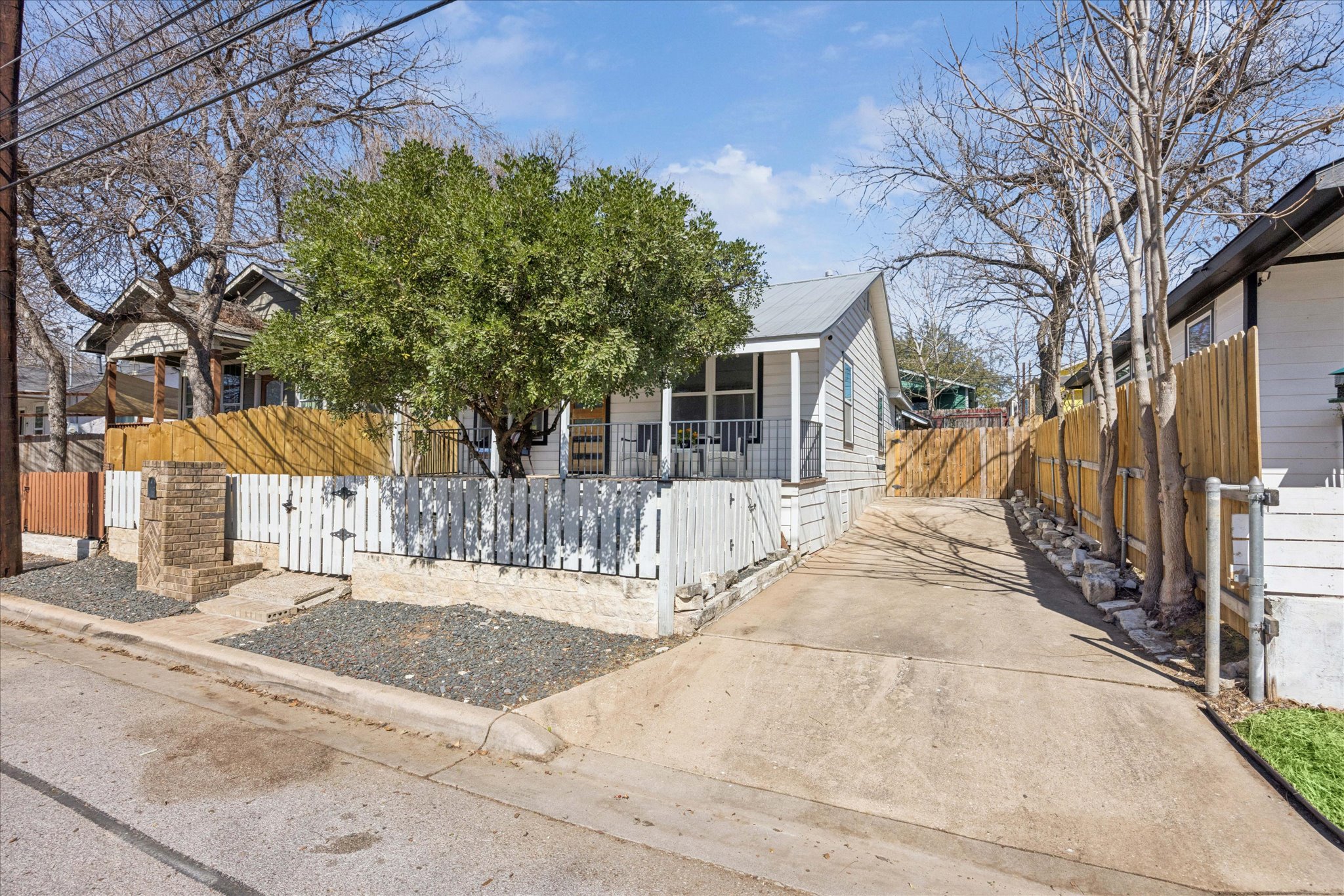 2306 Santa Maria Street Austin, TX 78702 - Photo 17 of 17 a view of a white house with a large tree and wooden fence
