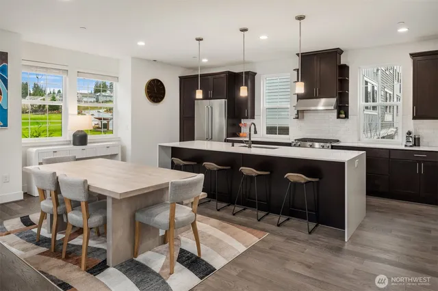 a kitchen with a table chairs refrigerator and microwave