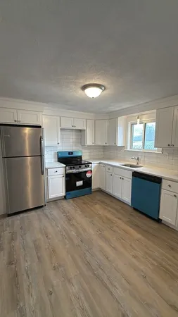 a large kitchen with stainless steel appliances granite countertop a stove a sink dishwasher and a refrigerator