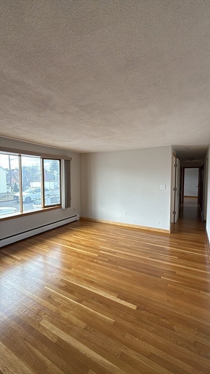 83 Pemberton Street, Unit A Revere, MA 02151 - Photo 5 of 13 a view of empty room with wooden floor and fan