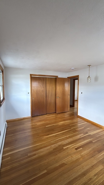 83 Pemberton Street, Unit A Revere, MA 02151 - Photo 8 of 13 a view of an empty room with window and wooden floor